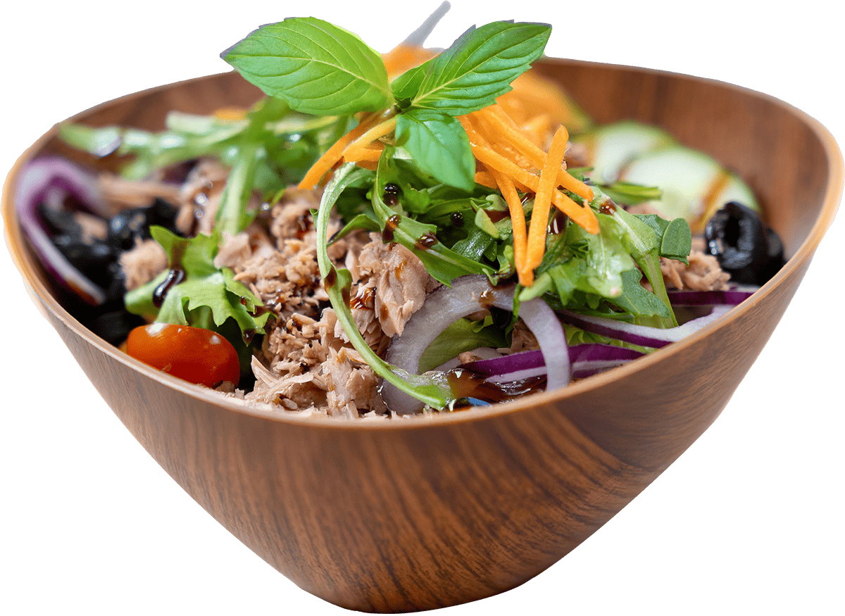 Thunfischsalat angerichtet in Holzschale, dekoriert mit zarten Karottenspänen und Basilikum