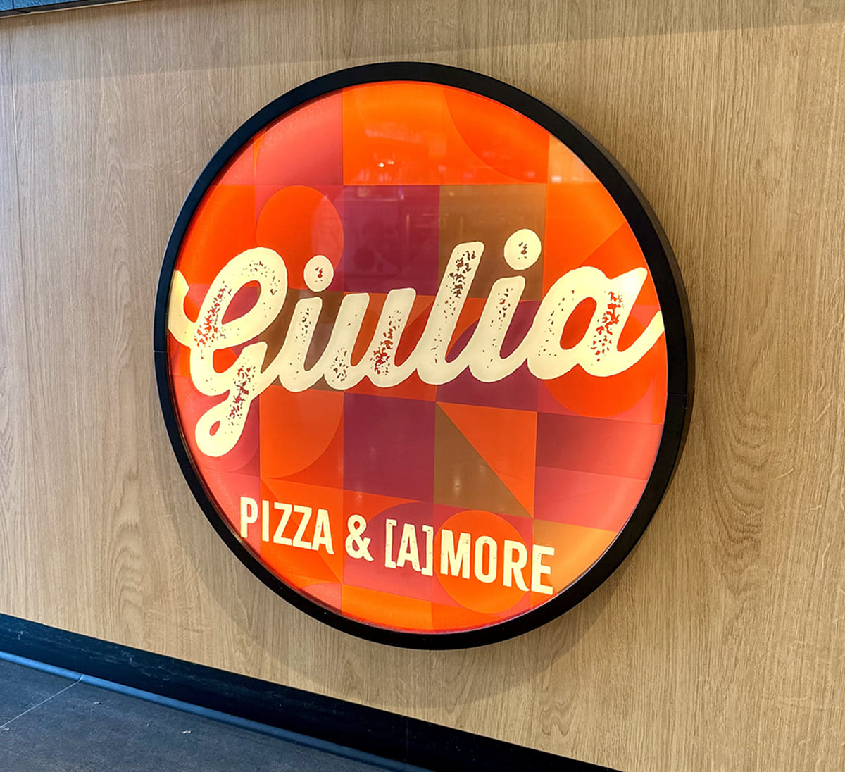 Logo Leuchtschild von Giulia Pizza an der Holztheke in den Mercaden in Böblingen