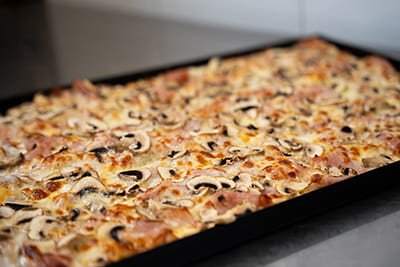 Blechpizza mit Schinken und Pilzen