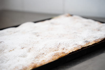 Blechpizza mit Nutella und Ricotta, bestreut mit Puderzucker