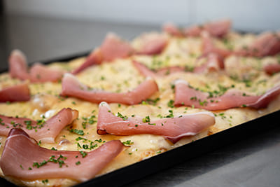 Blechpizza mit Provolakäse und Speck