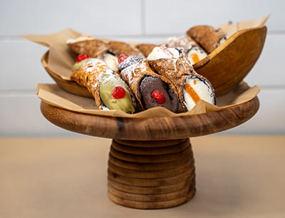 Cannoli angerichtet in einer Holzschale